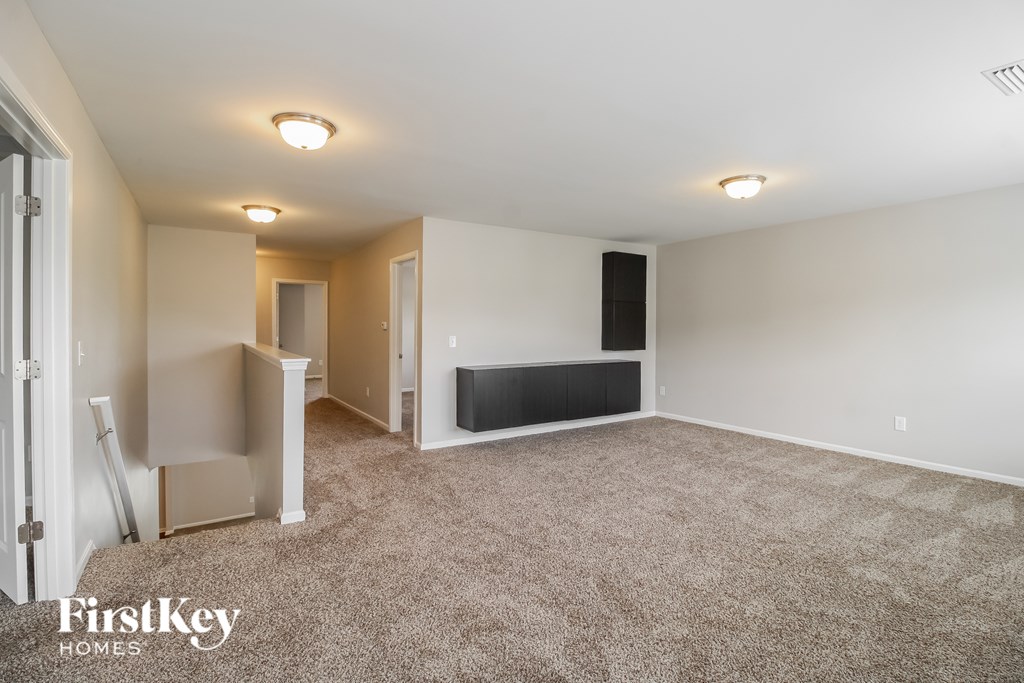 A room with a carpeted floor and a white ceiling with lights.