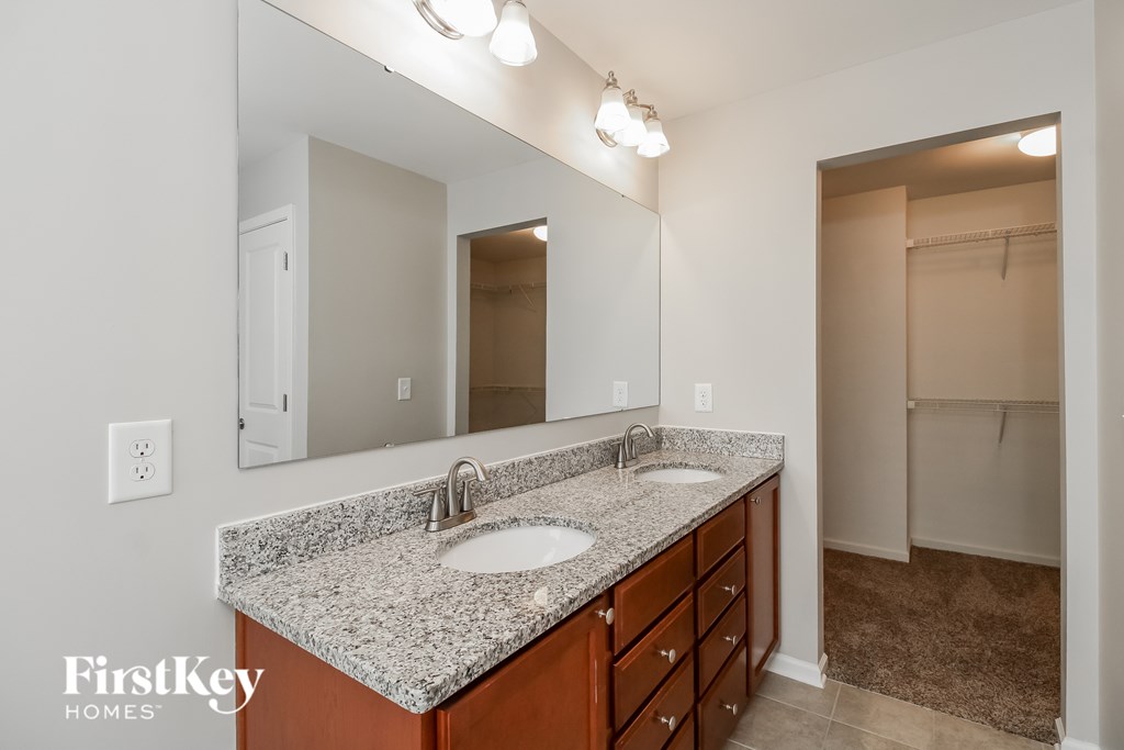 A bathroom with a granite countertop and a mirror above the sink.