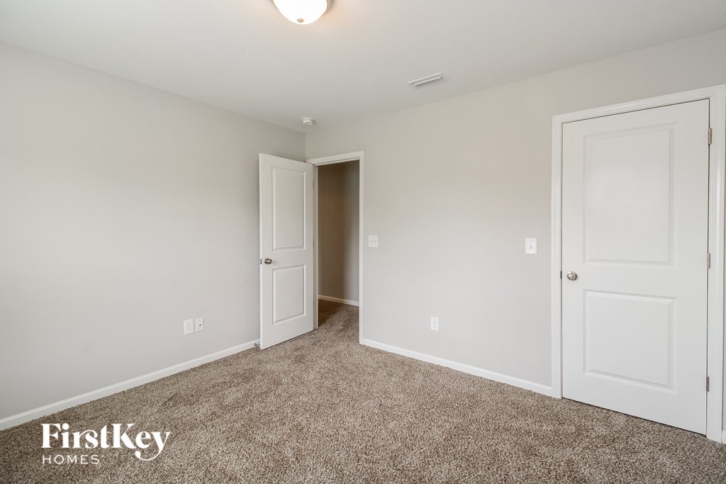 A room with two doors and a carpeted floor.