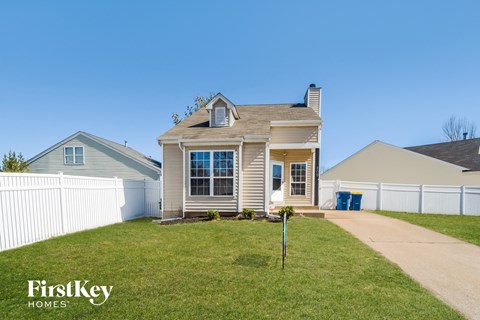 a white house with a yard and a white fence