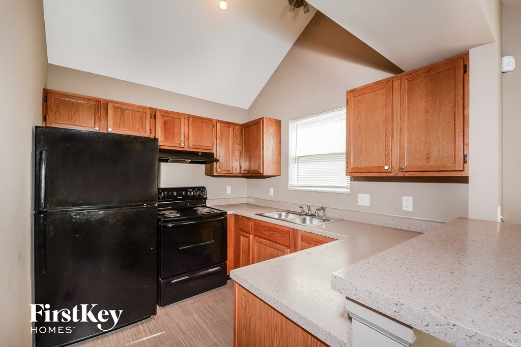 full view of kitchen with black appliances and white counter tops