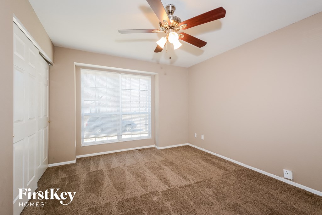 the living room is spacious and clean with a ceiling fan