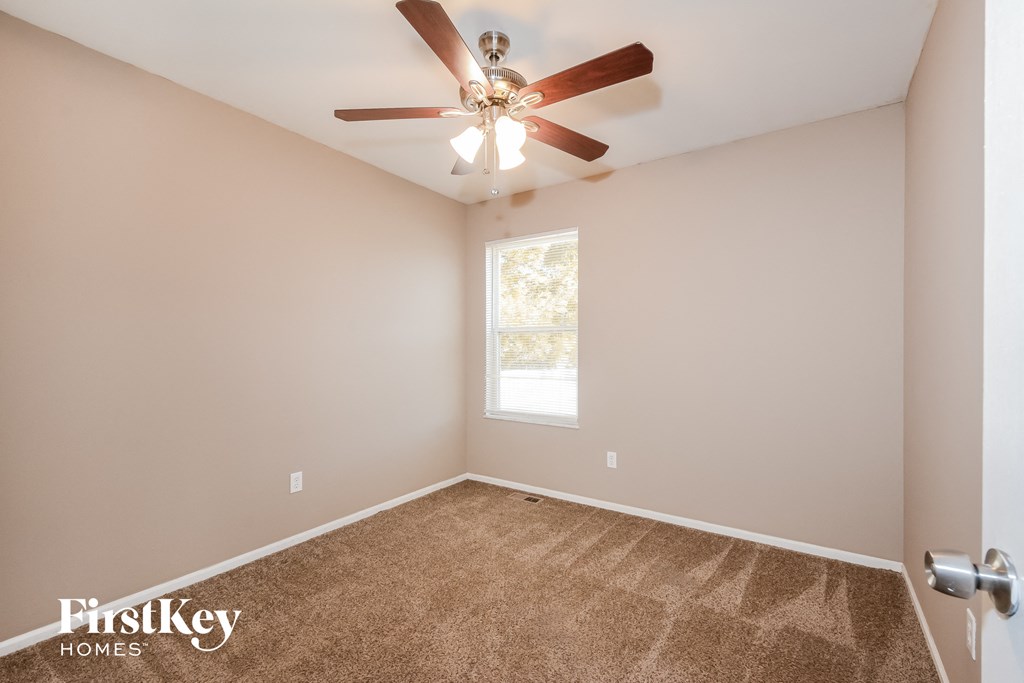 the great room has a ceiling fan and carpet