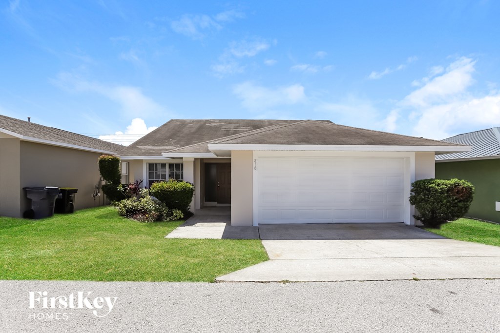 A house with a garage and a driveway in front of it.