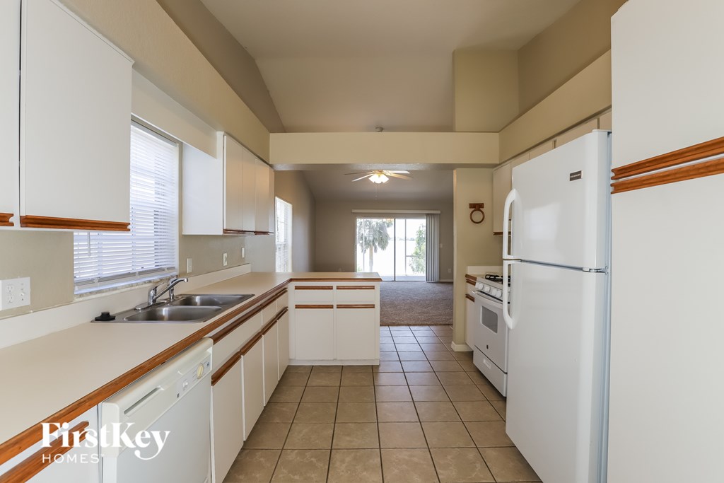 A kitchen with white appliances and cabinets.