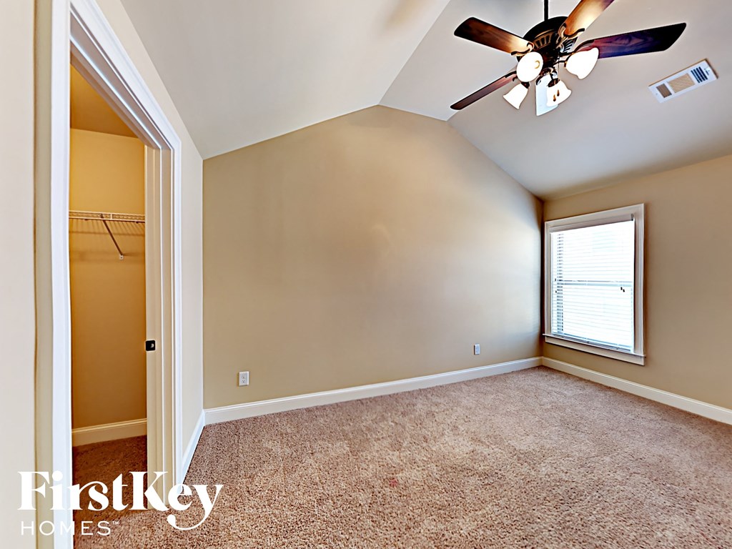 the master bedroom has a ceiling fan and a closet