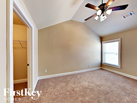 the master bedroom has a ceiling fan and a closet