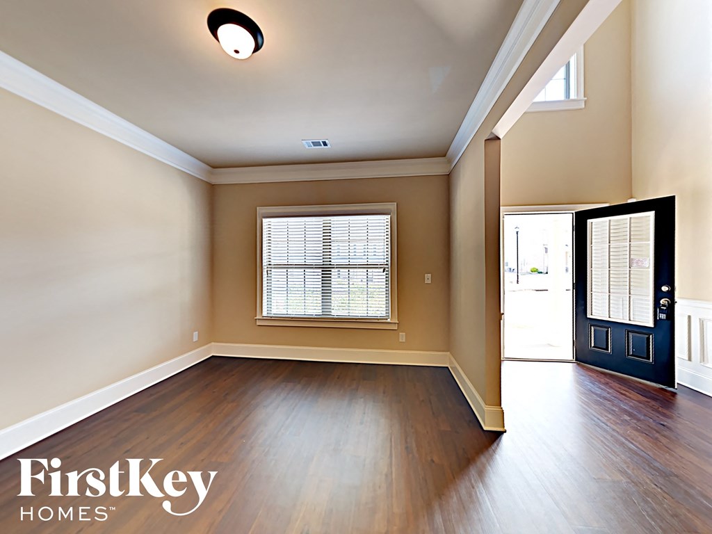 an empty living room with hardwood flooring and a window