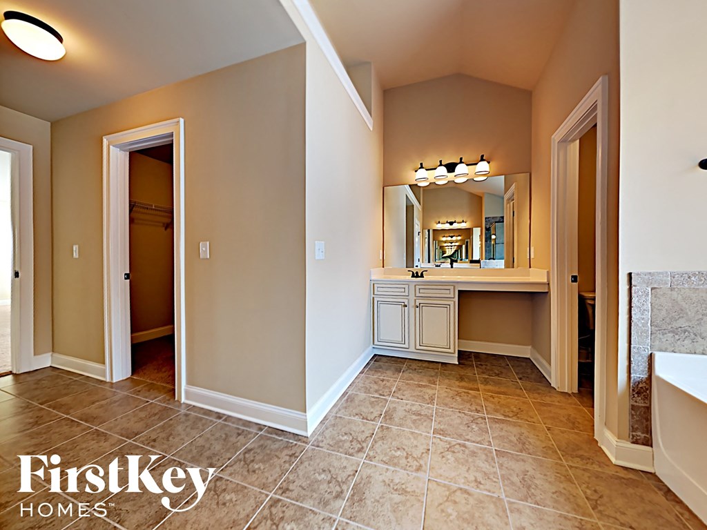 a bathroom with a sink and a mirror and a door way to a closet