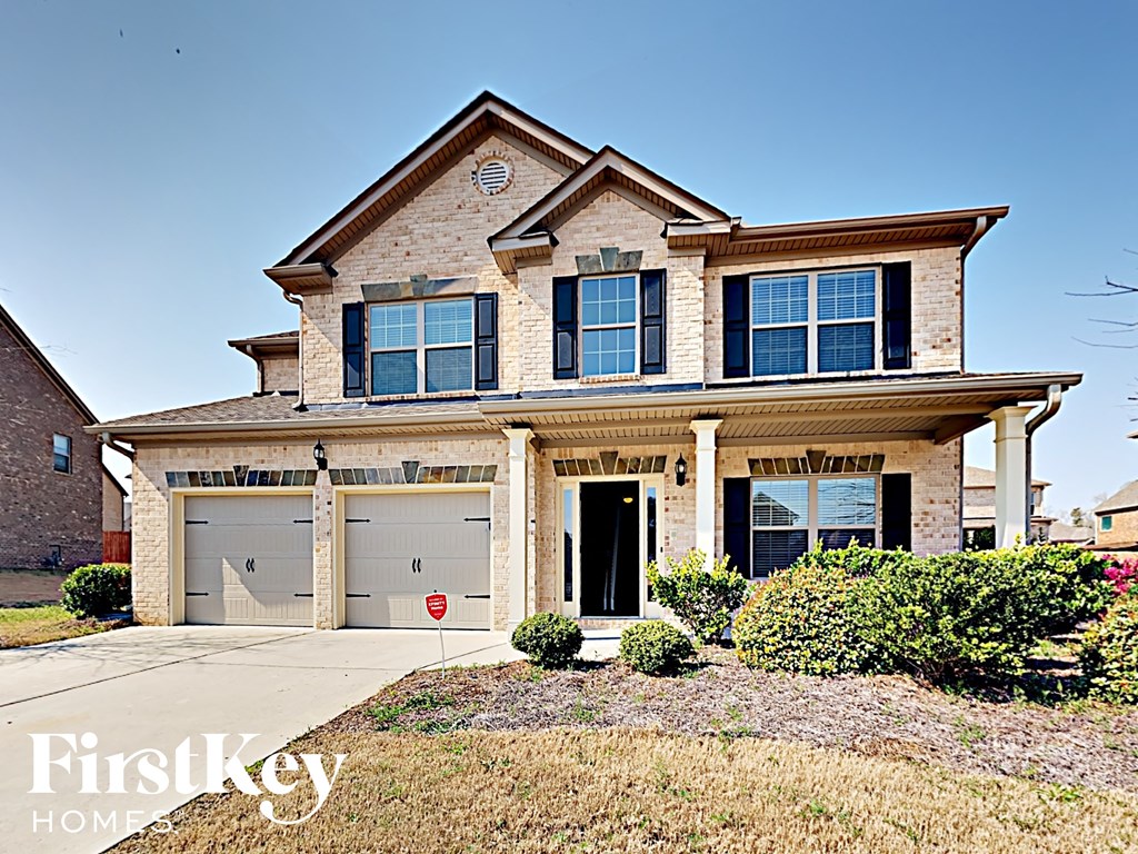 a house with two garage doors and a sidewalk in front of it