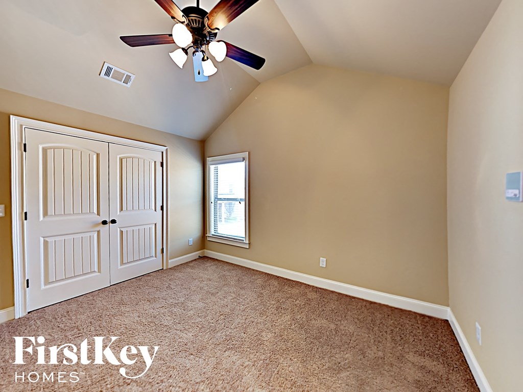 the master bedroom has a ceiling fan and a window
