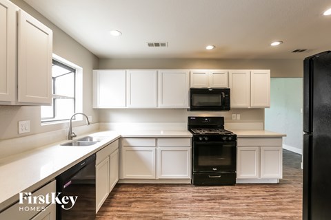 A kitchen with a black stove top oven and a black refrigerator.