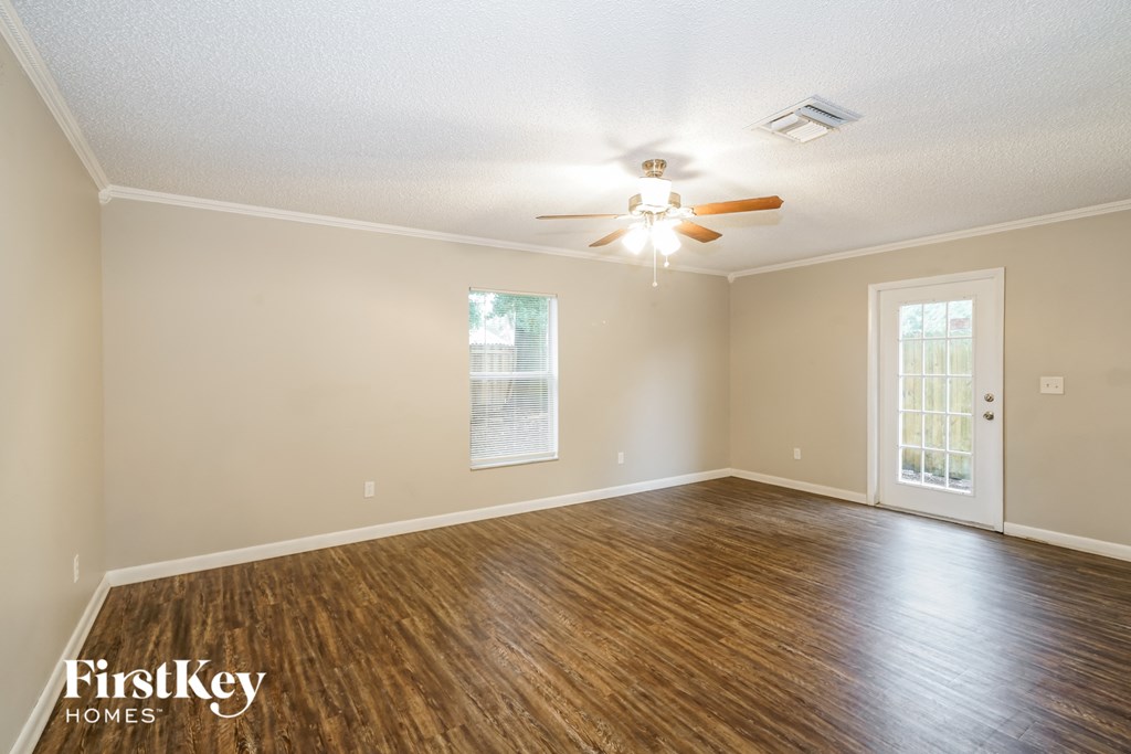 the living room of an empty house with a ceiling fan