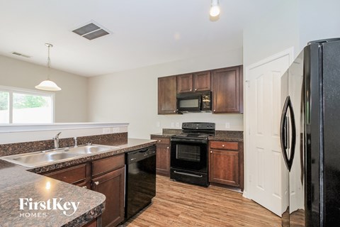 A kitchen with a black fridge and a black oven.