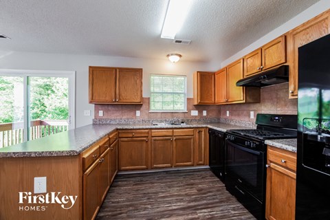 a kitchen with wood cabinets and black appliances and a counter top
