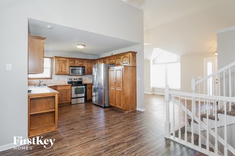 A kitchen with wooden cabinets and a white fridge.