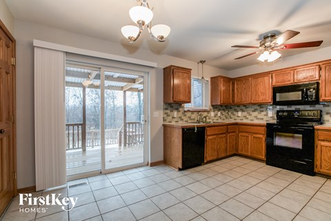A kitchen with wooden cabinets and a black stove top oven.