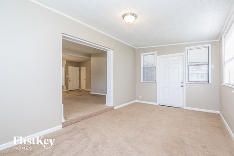 A room with a carpeted floor and a white door.