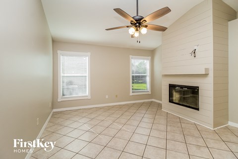 a living room with a fireplace and a ceiling fan