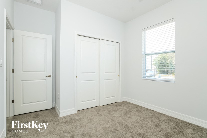 a bedroom with two white doors and a window