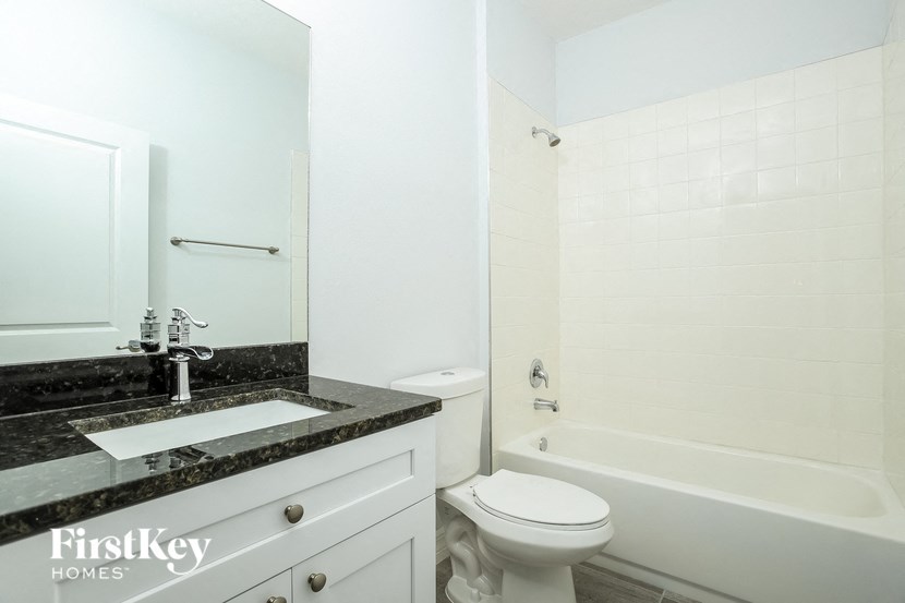 a white bathroom with a sink toilet and tub