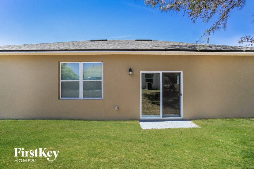 a tan house with a yard and a glass door