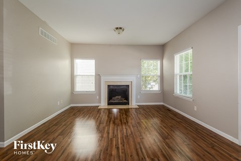 a living room with wood floors and a fireplace