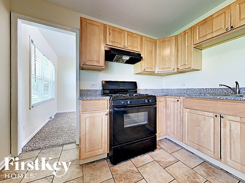 A kitchen with wooden cabinets and a black stove top oven.