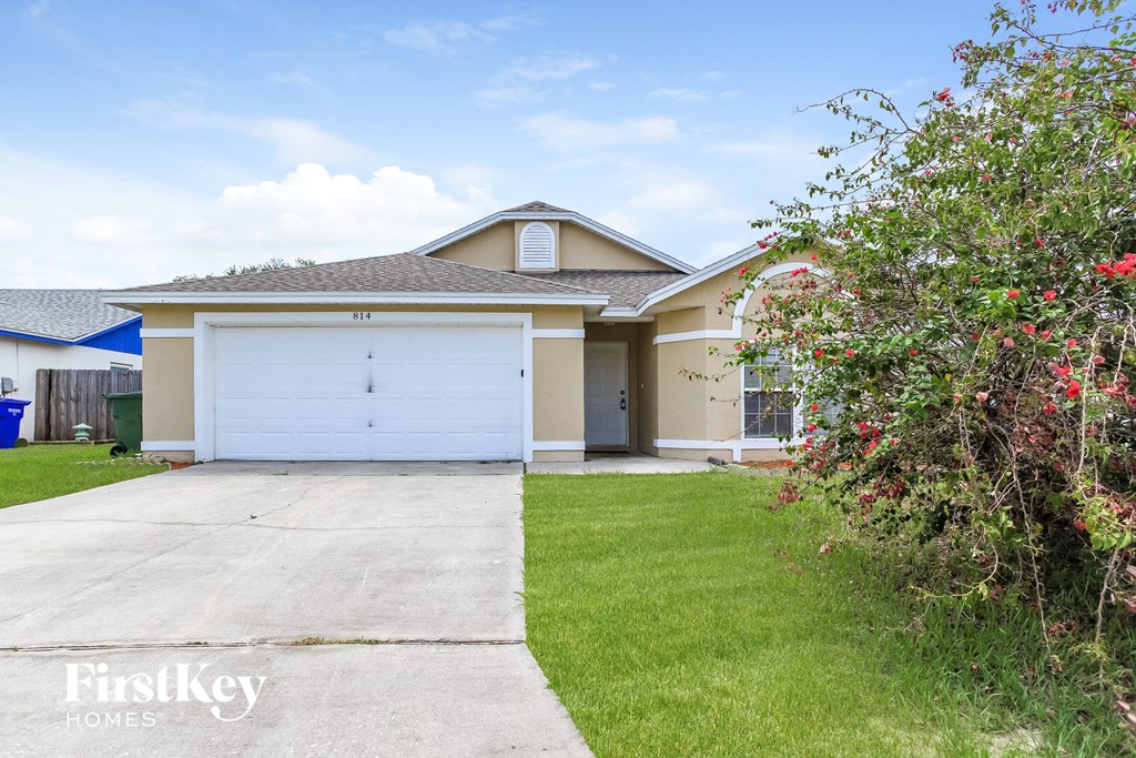 A house with a garage and a driveway in front of it.