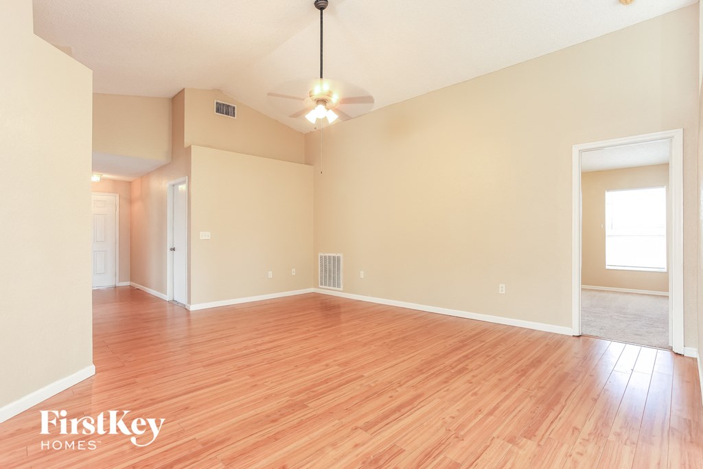 A room with wooden floors and a light fixture hanging from the ceiling.