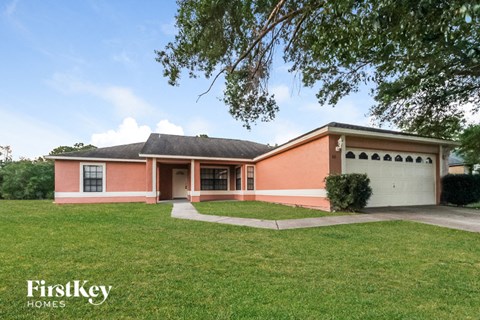 a brick house with a lawn and a white garage door