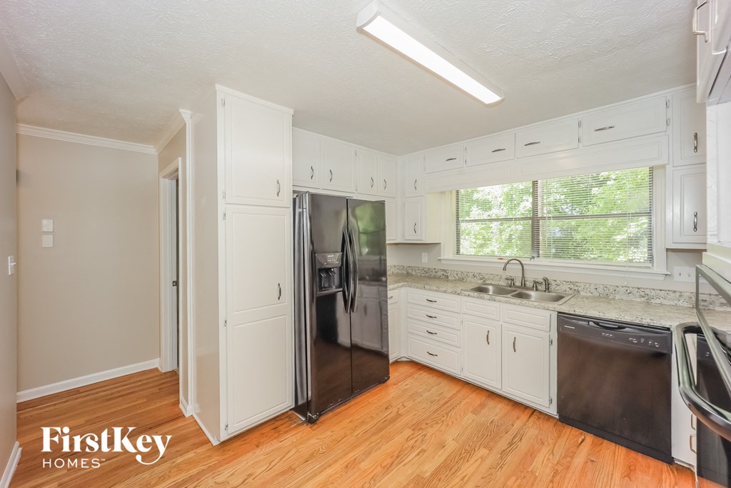 a kitchen with white cabinets and a stainless steel refrigerator