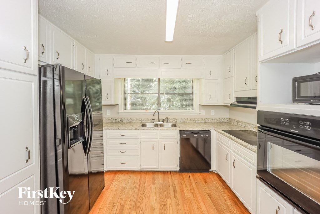 a white kitchen with stainless steel appliances and white cabinets