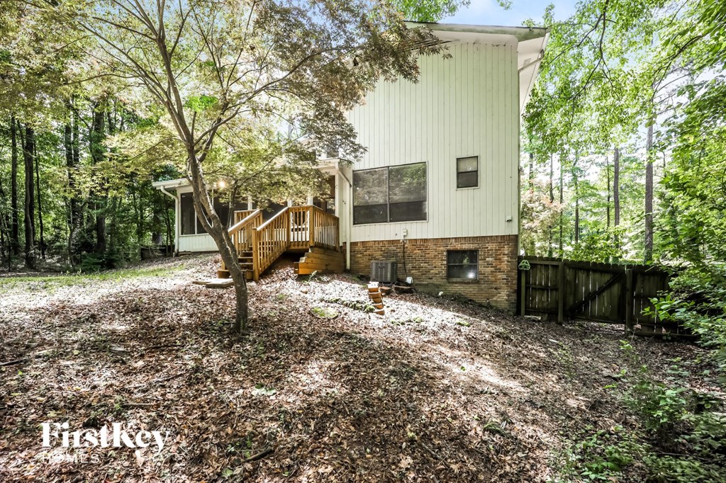 a home in the woods with a yard with trees and a house