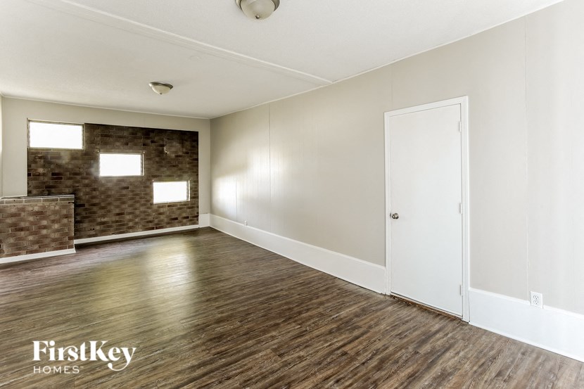 A room with wooden flooring and a white door.