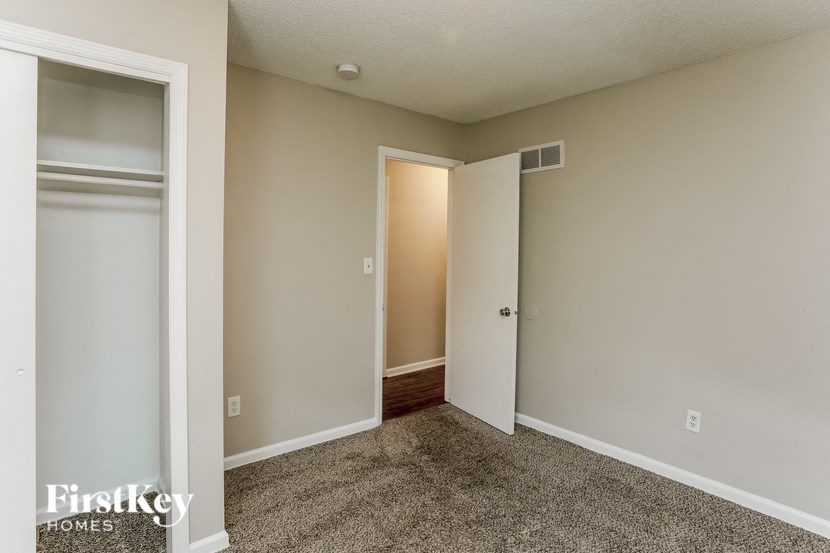 A room with a carpeted floor and a doorway leading to another room.