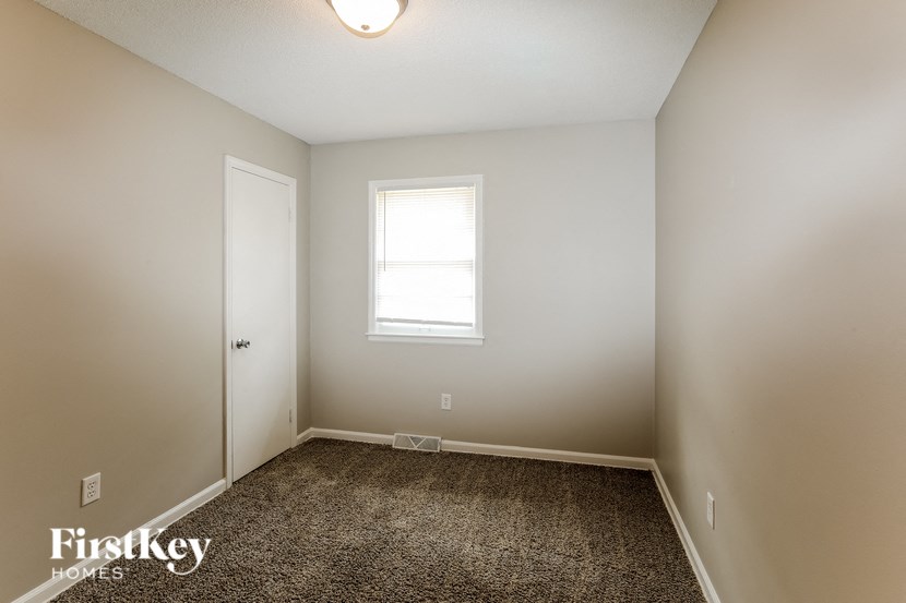 A room with a carpet floor and a window.