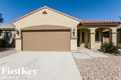 A house with a tan garage door and a brown roof.