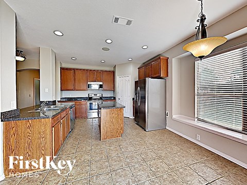 A kitchen with wooden cabinets and a tile floor.