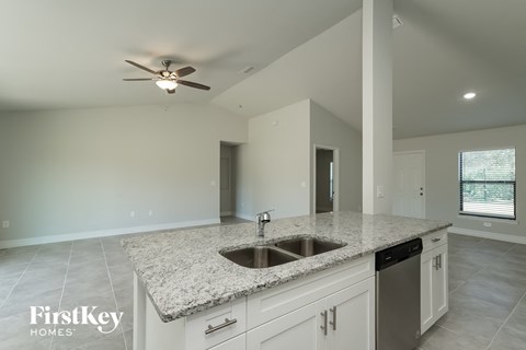 a kitchen with white cabinets and a granite counter top