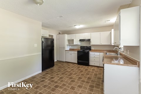 a white kitchen with black appliances and white cabinets