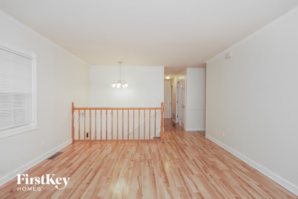 a spacious living room with hardwood flooring and a balcony