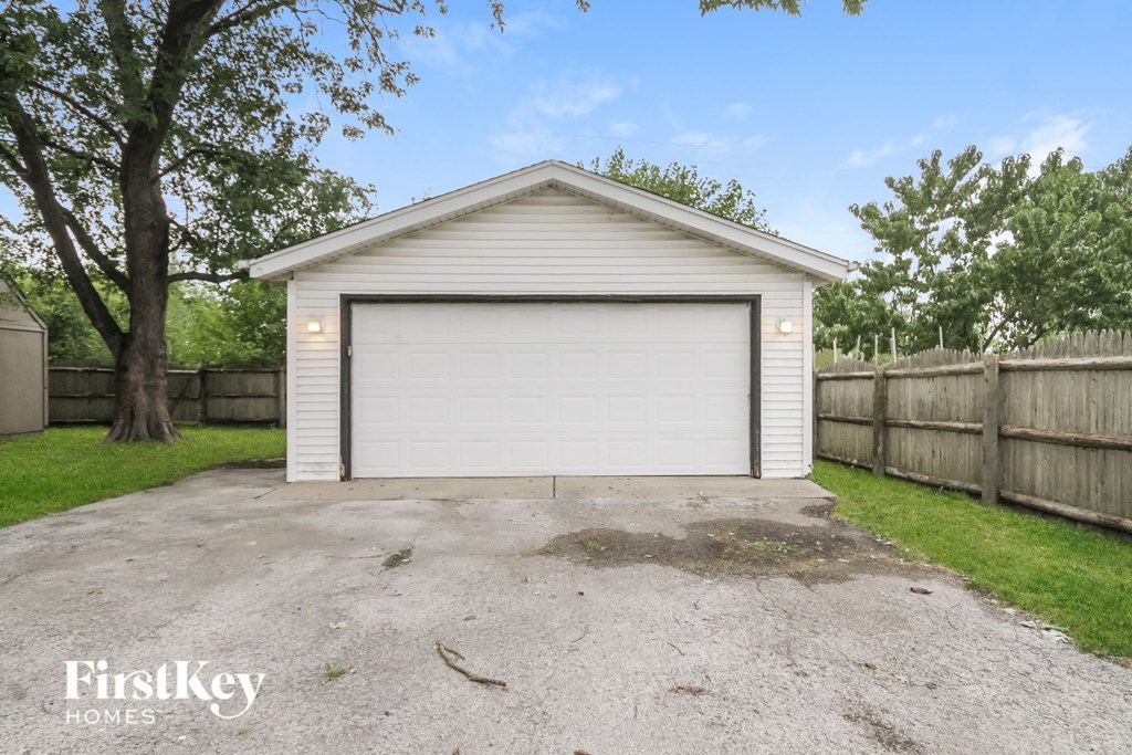 a garage with a white garage door on the side of a driveway