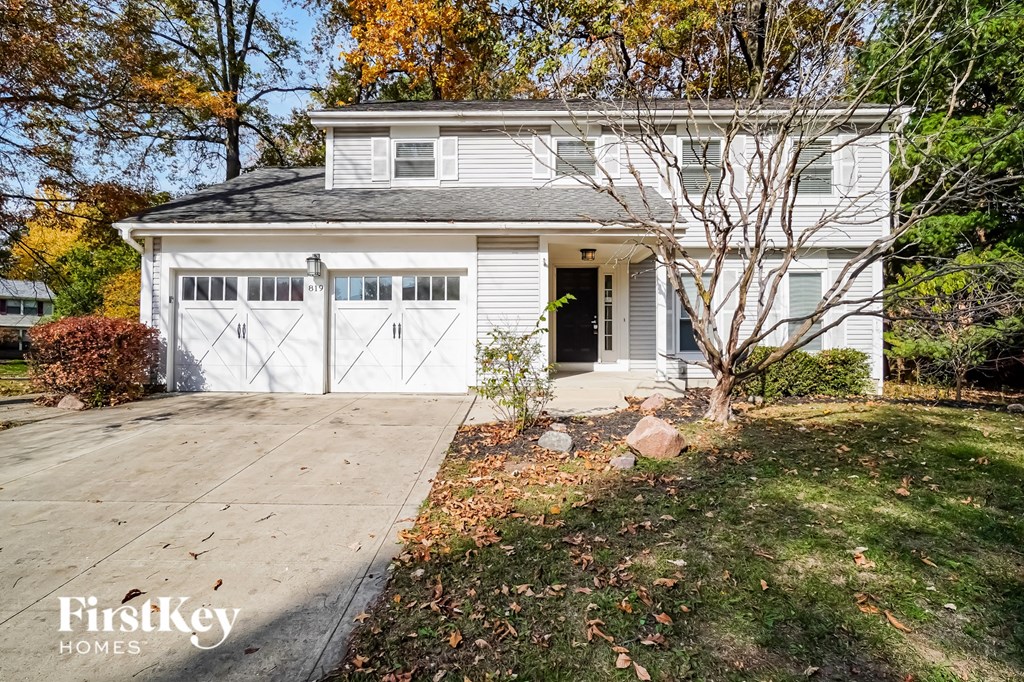 a white house with a driveway and a garage door