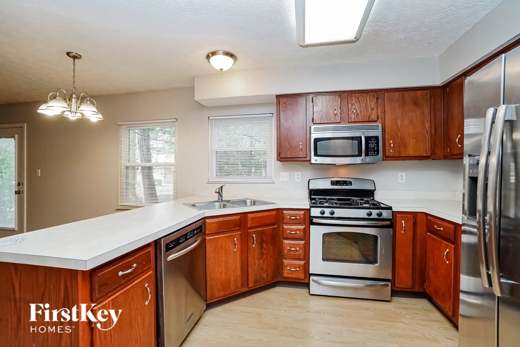 a kitchen with wooden cabinets and stainless steel appliances