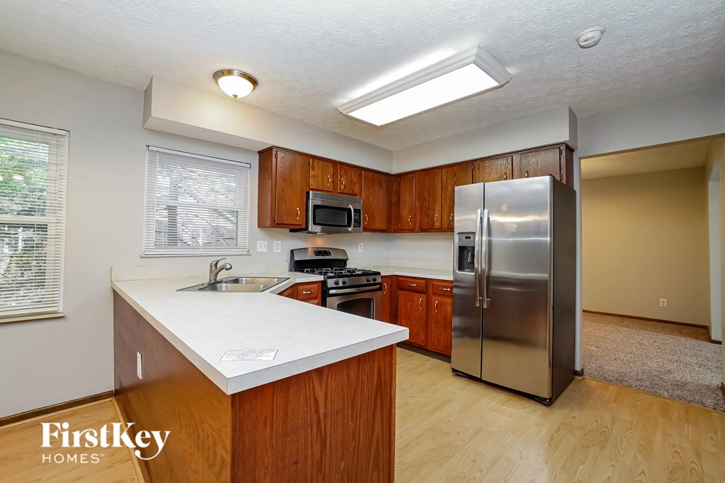an updated kitchen with stainless steel appliances and white counter tops