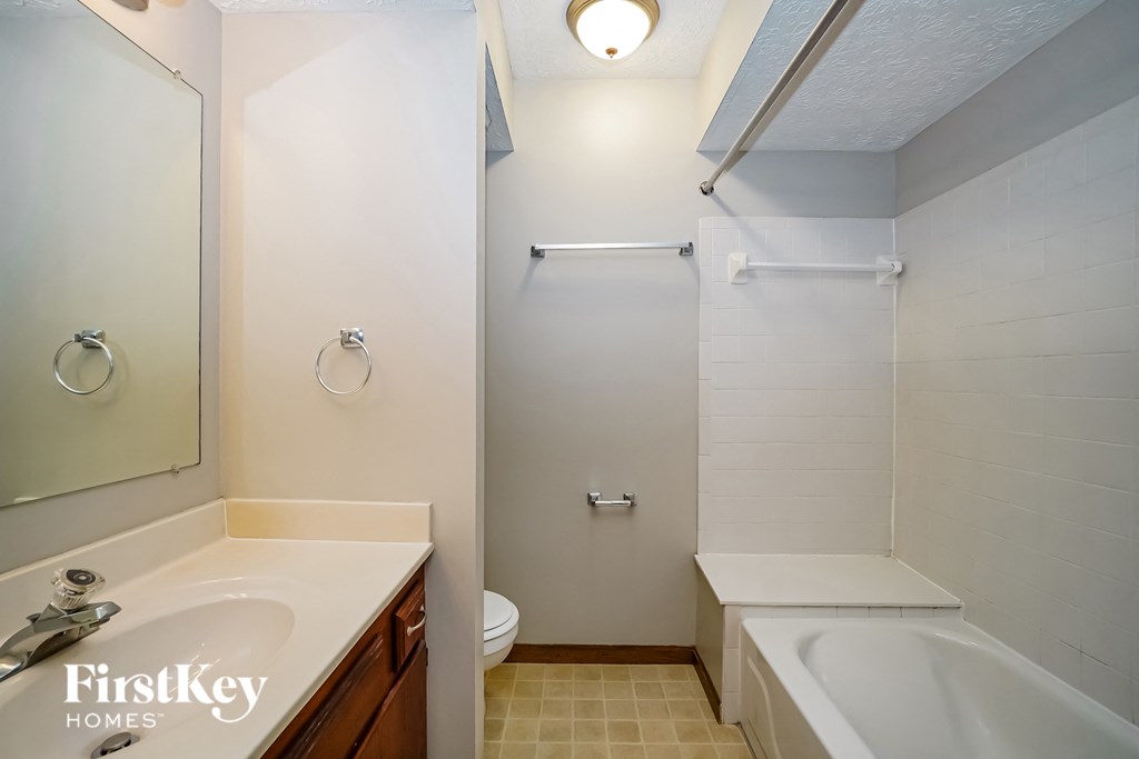 a small bathroom with a sink toilet and shower and a tub