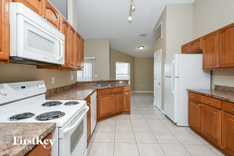 a kitchen with white appliances and wooden cabinets