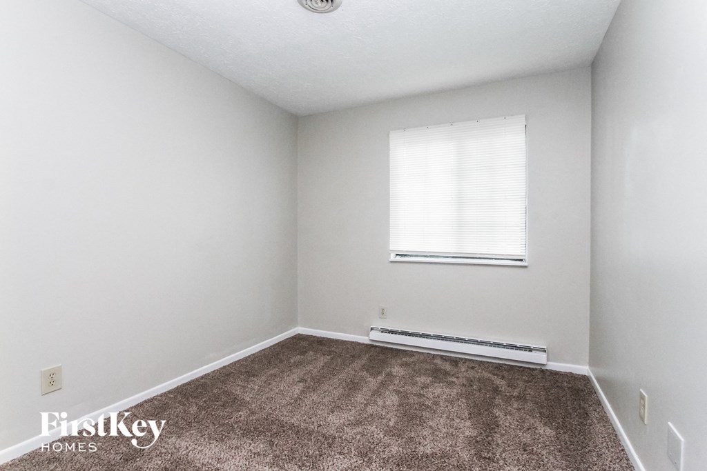 a white room with a carpet and a window