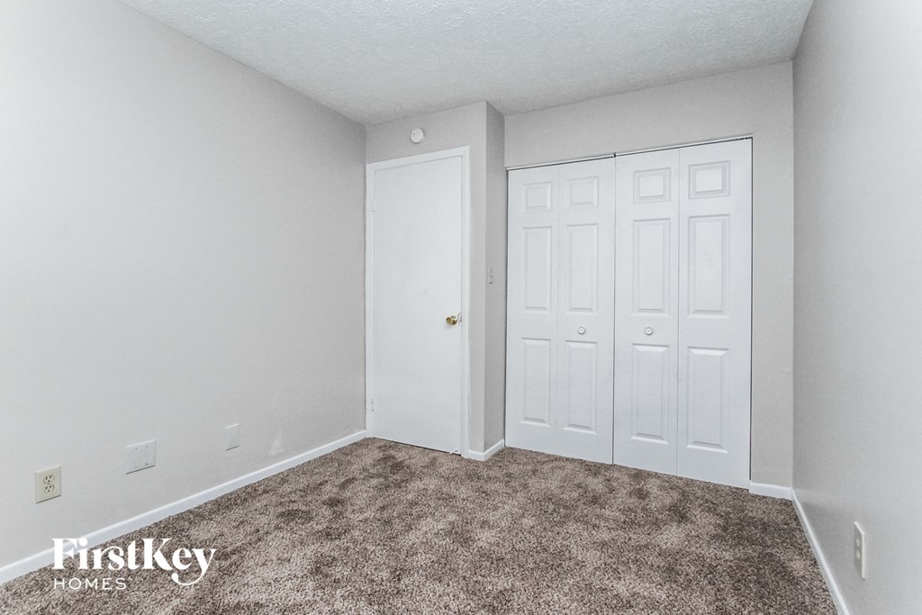a bedroom with a carpeted floor and white doors